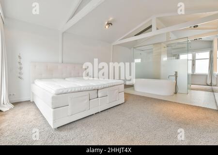 Vasca da bagno bianca posta vicino alla finestra in un elegante bagno con  pareti piastrellate beige in un moderno appartamento di giorno Foto stock -  Alamy