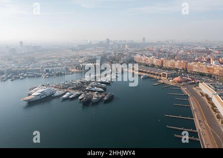 Vista panoramica aerea della città moderna vicino al porto sereno con barche ormeggiate nel porto industriale di Valencia Foto Stock
