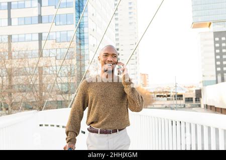 Giovane donna asiatica in abiti casual con telefono cellulare in le mani si siedono da sole al tavolo nel cafe e' in attesa ordine Foto Stock