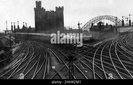 Con uno sfondo antico e moderno - il Flying Scotsman Express si avvicina alla stazione di Newcastle sulla sua corsa non-stop da Edimburgo a Londra. Il vecchio castello e il nuovo ponte Tyne si possono vedere sullo sfondo. La famosa stazione ferroviaria centrale di Newcastle attraversa prima della nazionalizzazione. 11th agosto 1932. Foto Stock