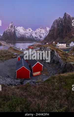 Da sopra di piccole case rosse situate in aspra valle rocciosa circondata da alte montagne nelle isole Lofoten in Norvegia Foto Stock