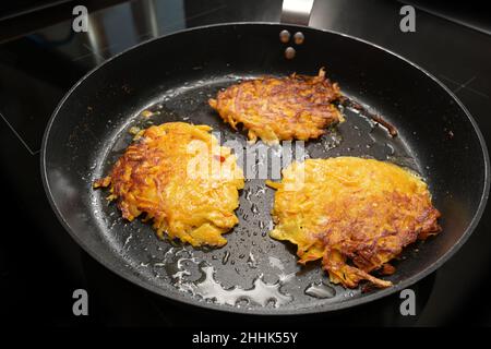 Frittelle arrosto di zucca rossa kuri e patate in una padella nera, dette anche frittelle di zucca, rosti o crocchette di patate, ricetta di verdure autunnali, copia spa Foto Stock