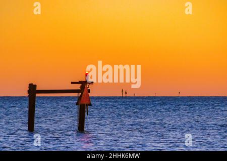 Un faro diurno è illuminato al crepuscolo quando il sole tramonta sull'acqua, 4 gennaio 2016, a Bayou la Batre, Alabama. Foto Stock