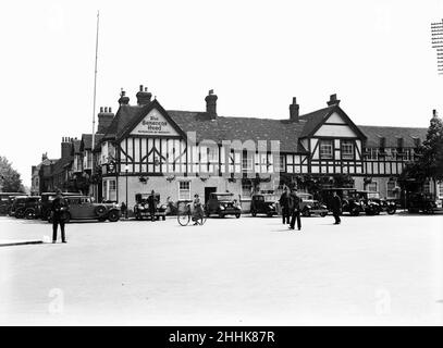 Saracens Head Beaconsfield Circa 1936Police traffico diretto e pattuglia al di fuori del Saracens Head, Beaconsfield, mentre un sconosciuto visitatore reale gode di un drink al pub. Foto Stock