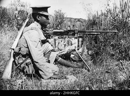 Guerra Abissiniana Settembre 1935Abyssinian mitragliatrice che spara una vecchia mitragliatrice Hotchkiss sul fronte Ogadan durante l'invasione italiana dell'Abissinia. Foto Stock