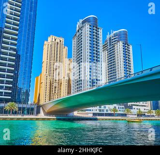 I moderni grattacieli di vetro e cemento dietro al ponte al Gharbi attraverso Dubai Marina, Emirati Arabi Uniti Foto Stock