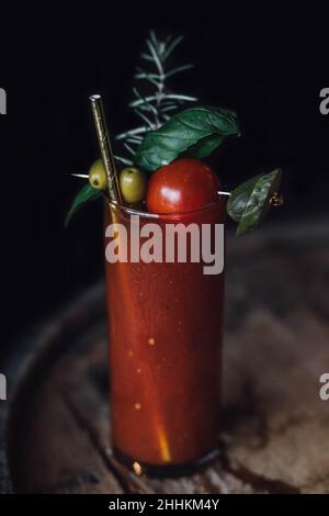 Single Bloody Mary drink cocktail con cannuccia d'oro bevente e un sacco di guarnire Foto Stock