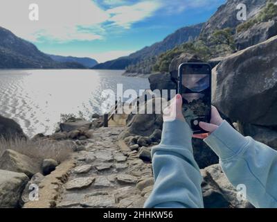 Yosemite National Park, CA, U.S.A. 24th Jan, 2022. Un escursionista scatta una foto della riserva di Hetch Hetchy e del sentiero escursionistico con il suo iPhone. Il lago artificiale di Hetch Hetchy ha un'escursione perfetta intorno al lato nord del serbatoio. (Credit Image: © Marty Bicek/ZUMA Press Wire) Foto Stock