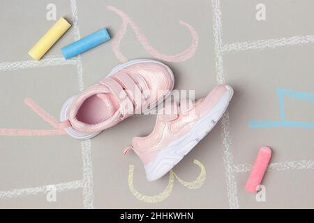 Sneakers rosa e hopscotch gioco. Vista dall'alto, disposizione piatta. Foto Stock