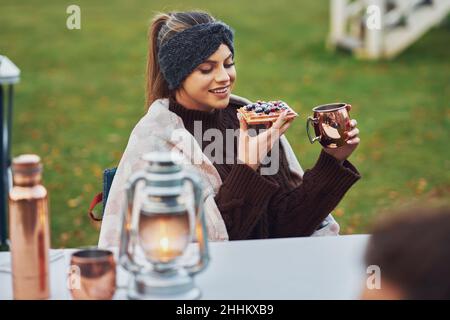 Giovane coppia piacevole divertirsi in campeggio mentre cucinano e mangiano Foto Stock