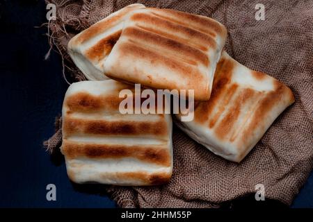 Tradizionale sudafricano pane griddle o roosterkoek su superficie rustica con spazio copia Foto Stock