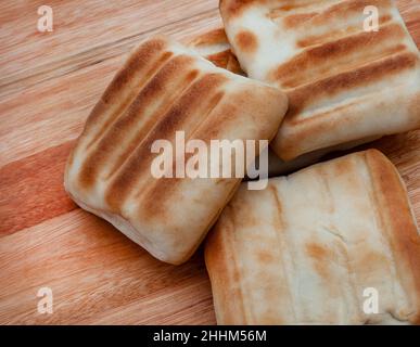 Tradizionale sudafricano pane griddle o roosterkoek su superficie rustica con spazio copia Foto Stock