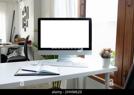 Computer desktop con schermo vuoto nella sala ufficio con decorazioni e spazio per fotocopie Foto Stock