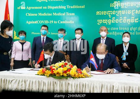 Phnom Penh, Cambogia. 25th Jan 2022. Huang Luqi (L, fronte), vice-commissario in visita dell'Amministrazione Nazionale della Medicina tradizionale Cinese (NATCM), e il ministro della Sanità della Cambogia MAM Bunheng (R, fronte) firmano un accordo a Phnom Penh, Cambogia, 25 gennaio 2022. La Cina e la Cambogia hanno firmato martedì un accordo sulla spedizione di un team di esperti di medicina tradizionale cinese per aiutare la Cambogia nella lotta contro il COVID-19. Credit: Phearum/Xinhua/Alamy Live News Foto Stock