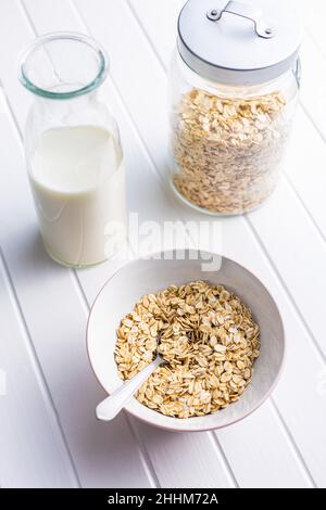 Colazione cereali. Farinata d'avena cruda. Fiocchi di avena crudi nel recipiente. Foto Stock