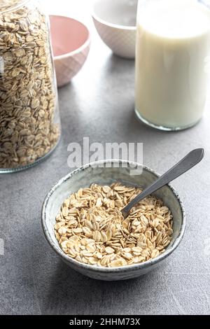 Colazione cereali. Farinata d'avena cruda. Fiocchi di avena crudi nel recipiente. Foto Stock