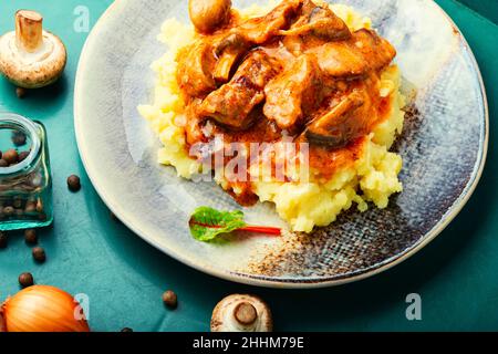 Carne di stroganoff di manzo appetitosa. Carne con funghi e purè di patate Foto Stock