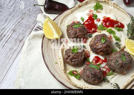 Polpette di manzo e agnello tradizionali fatte in casa con pane arabico, salsa di pomodoro, melograno ed erbe aromatiche. Halal cibo Foto Stock