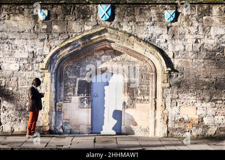 Uno studente all'ingresso dell'ex monastero medievale carmelitano, ora college Worcester, università di Oxford, Inghilterra. Foto Stock