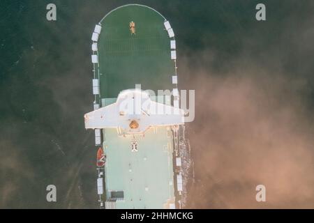 Colpo dall'alto di un vettore di auto roro al mattino presto con nave mercantile e nebbia che arriva al porto di Southampton. Foto Stock