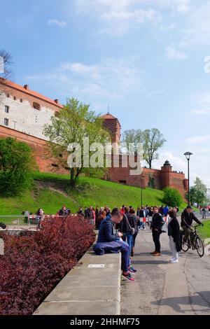 CRACOVIA, MALOPOLSKIE POLONIA - 30 Aprile 2017: I turisti visitano il Castello reale di Wawel. Persone che camminano lungo il fiume Vistula Foto Stock