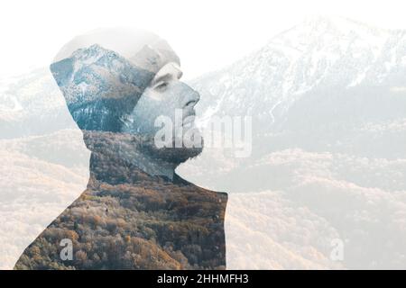 Doppia esposizione di uomo viaggiatore con barba contro montagne autunnali con neve. Foto Stock