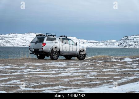 Teriberka. Regione di Murmansk, russia. 12 dicembre 2021: Nissan SUV si trova sulla riva del Mare di Barents, l'Oceano Artico. L'Artico russo. Foto Stock