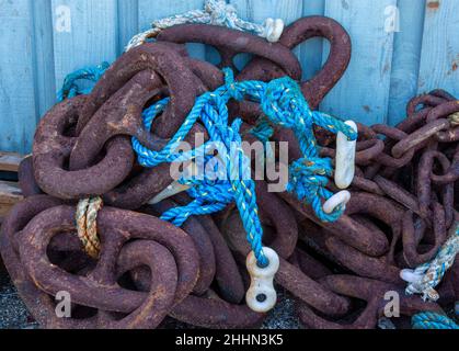 Funi da pesca blu e catene accatastate in un angolo della banchina. Asciugando fuori pronto per uso Foto Stock