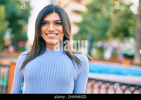 Bella donna ispanica sorridente confidente al parco Foto Stock