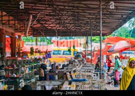 Mercato locale di frutta e verdura con molti venditori e acquirenti a Zanzibar, Tanzania Foto Stock