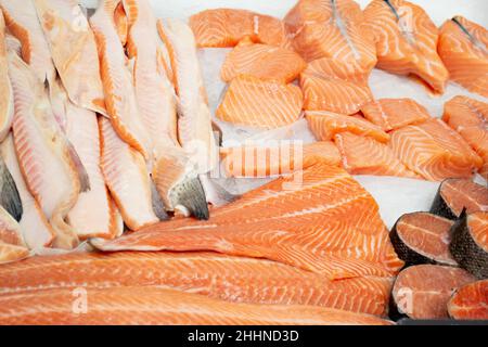 Primo piano vendita di bistecche refrigerate e dorso di salmone e trota su ghiaccio. Foto Stock