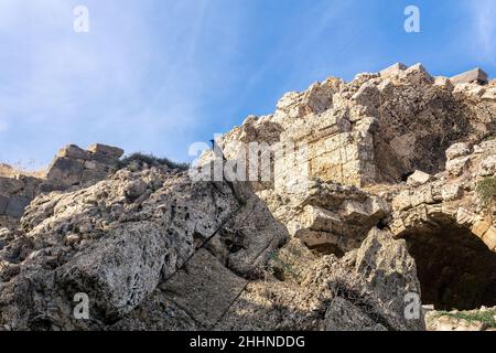 crow siede su una pietra di alcune antiche rovine contro il cielo Foto Stock