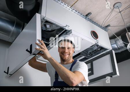 sorridente tecnico hvac al lavoro. ventilazione, manutenzione e riparazione dell'impianto di riscaldamento Foto Stock