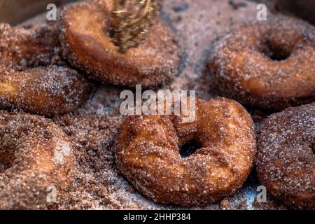 Ciambelle di zucchero alla cannella fatte in casa nella padella in ghisa all'aperto. Foto Stock