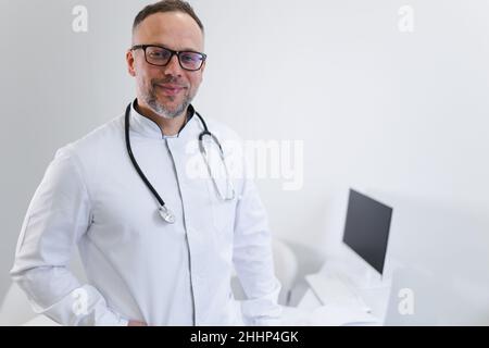Ritratto di bel medico caucasico maschile di mezza età in clinica Foto Stock