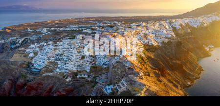 Pittoresca vista aerea drone del famoso villaggio di Oia con case bianche durante l'alba sull'isola di Santorini, Grecia, Europa. Viaggi di lusso. Vacanze estive Foto Stock