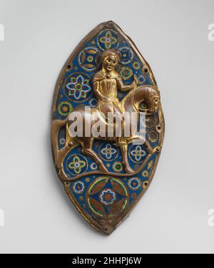 Placca equestre ca. 1220 Francese questo cavaliere sicuro, possedendo tutta la poise di un grande cavaliere, fu trovato prima del 1890 a Saint-Germain, nei pressi di Gourdon, nel sud-ovest della Francia. La sua identità e la funzione originaria della targa sono sconosciute. Il suo cuscinetto ha molto in comune con i re a cavallo dalla storia sacra raffigurata in vetrate dall'Abbazia di Saint-Germain-des-Prés (24,167a–k) esposta nelle vicinanze. Placca equestre. Francese. CA. 1220. Smalto e vetro Champlevé su rame dorato. Prodotto a Limoges, Francia. Smalti-Champlevé Foto Stock