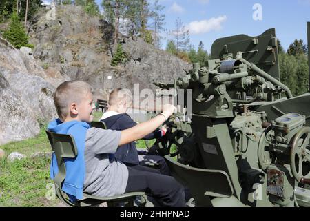 Bambini che giocano con la pistola automatica antiaerea S-60 a Gora Filina, Karelia Foto Stock