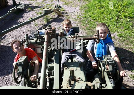 Bambini che giocano con la pistola automatica antiaerea S-60 a Gora Filina, Karelia Foto Stock