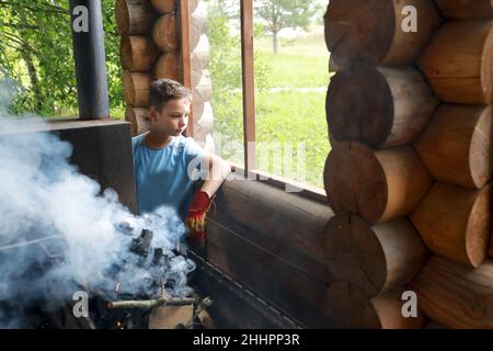 Legna da ardere di kindles capretto alla griglia in gazebo, Karelia Foto Stock