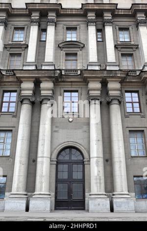 Si trova di fronte a un edificio storico grigio a San Pietroburgo, Russia Foto Stock
