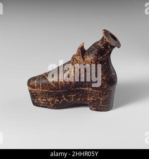 Fiasca di profumo in terracotta a forma di scarpa 1st secolo a.C. lidiana l'oggetto è costituito da un piccolo alabastron (vaso di profumo) inserito nell'apertura della scarpa. Il nome scritto sul lato, Hekataiou, dà il nome del proprietario, un uomo chiamato Hekataios. Fiasca di profumo in terracotta a forma di scarpa 252575 fiasca di profumo in lidiano, terracotta a forma di scarpa, 1st sec. a.C., terracotta, 2 3/8in. (6,1cm). Il Metropolitan Museum of Art, New York. Dono della Società americana per l'Escavazione di Sardis, 1926 (26.164.10) Foto Stock