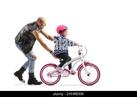 Bambina che cerca di guidare una bicicletta e un uomo che tiene la bicicletta isolata su sfondo bianco Foto Stock