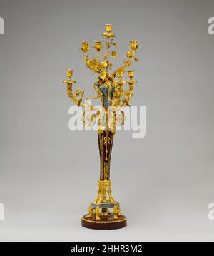 Coppia di candelabri a sette luci (candele o giranandole) ca. 1790 la Candelabra francese divenne sempre più elaborata nel corso del XVIII secolo e fu spesso colata di bronzo dorato. Monumentale per dimensioni, questo paio ha voluto contenere sette candele è molto complesso nel suo design. Disposto su due piani di tre rami e con un braccio aggiuntivo in alto, il modello incorpora due serie di piedi animali come supporto, zampe di leone e zoccoli di capra. Il gambo è sormontato da figure di termine femminili, possibilmente maenadi e i rami di scorrimento sul livello inferiore ciascuno terminano in un jester Foto Stock