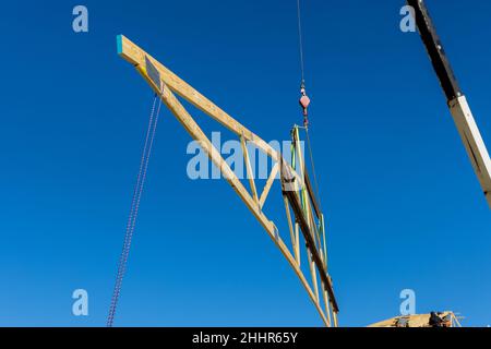 Nuova costruzione residenziale casa incorniciatura la gru tiene è tetto di legno Foto Stock