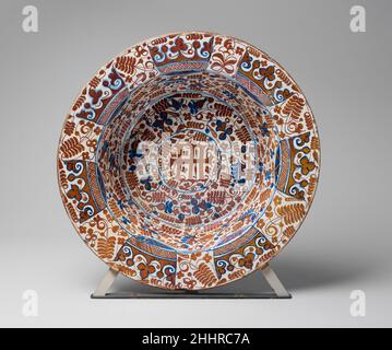 Deep Dish 1430–1440 i bacini profondi spagnoli di questo tipo erano comuni nelle case ricche della fine del XV secolo e probabilmente possono essere identificati con il termine bacin che compare in una serie di documenti. Una famiglia è registrata in possesso di 130 ciotole e bacini di vario genere, mentre un'altra, a Barcellona, è descritta come avente sei ciotole di arbusti appesi al muro. La profondità di questo bacino e l'ampio brigolo progettato per un facile trasporto indicherebbe che era riempito d'acqua ed era usato per lavare le mani ed il viso. Questo può essere il tipo descritto negli inventari di Re René, d Foto Stock