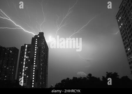 Immagine monocromatica di incredibili fulmini reali nel cielo notturno urbano Foto Stock