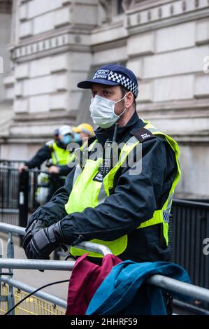 LONDRA, INGHILTERRA- 22 gennaio 2022: Ufficiale di polizia a Downing Street alla protesta del NHS100K contro i mandati di vaccino per il personale NHS Foto Stock