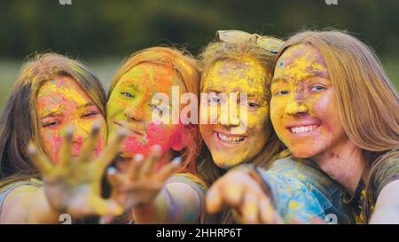 Ragazze allegre che posano strisciato in polvere multicolore. Foto Stock