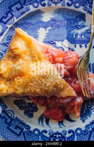 fetta di torta al rabarbaro alla fragola su un piatto giapponese blu Foto Stock